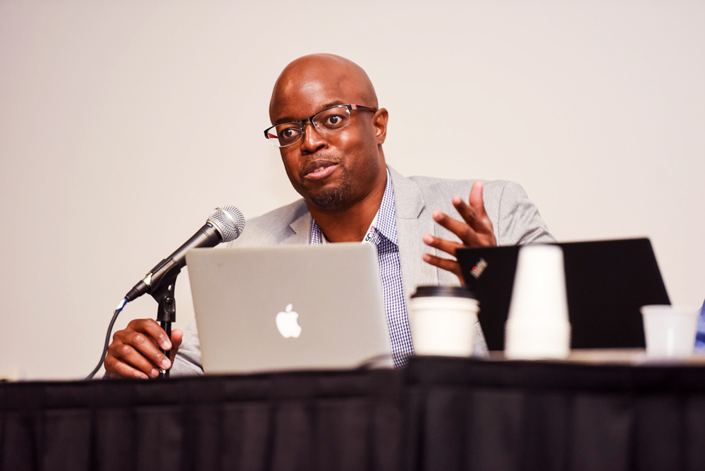 Man giving presentation in front of laptop.